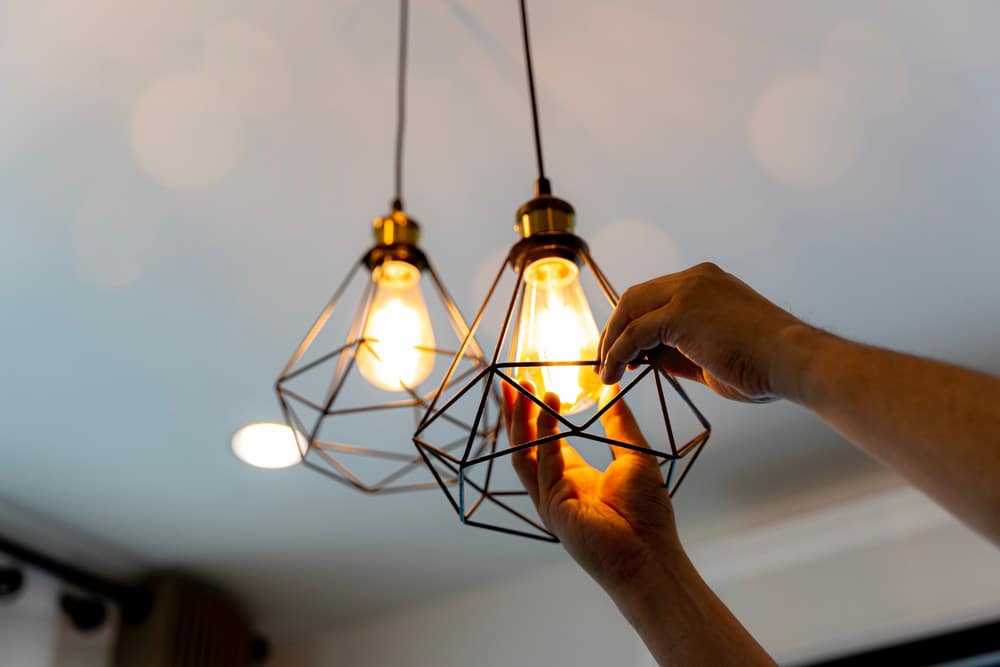 Glühbirne wird in eine Deckenlampe eingeschraubt