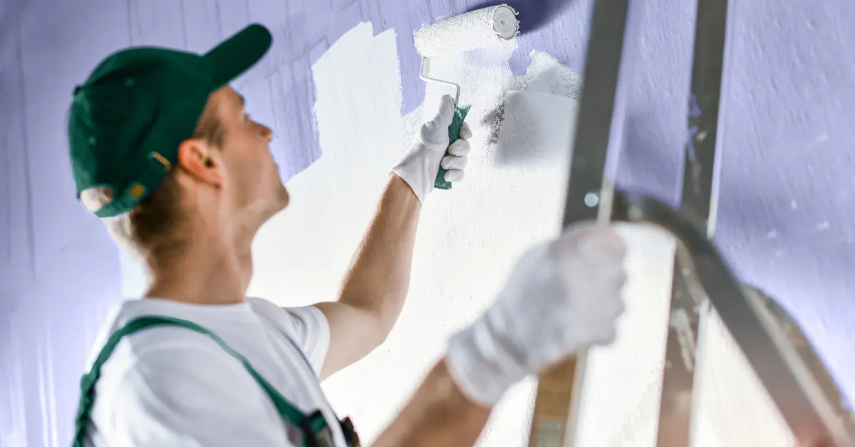 Professioneller Maler streicht eine Wand weiß