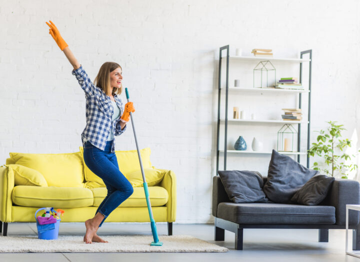 Smiling Young Woman Dancing Living Room With Cleaning Equipments
