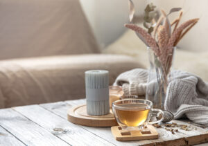 Cozy Autumn Home Composition With Cup Tea Candles Knitted Element Blurred Background Room Interior