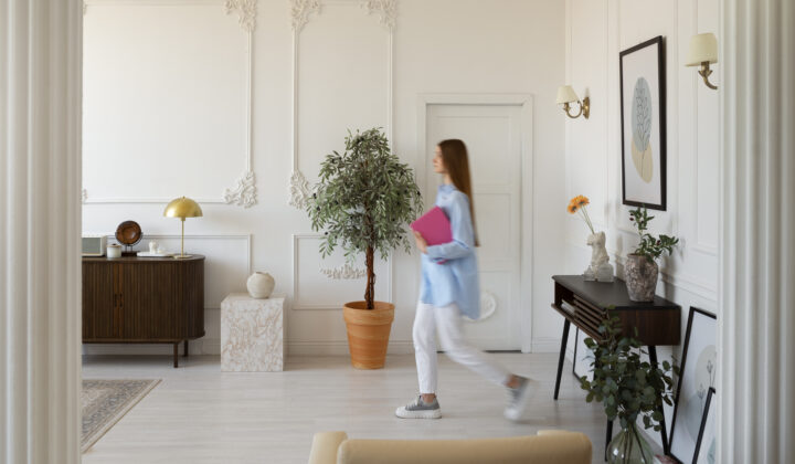 Person in heller Wohnung mit Pflanzen und Dekor, geht schnell vorbei, reinigungskraft.