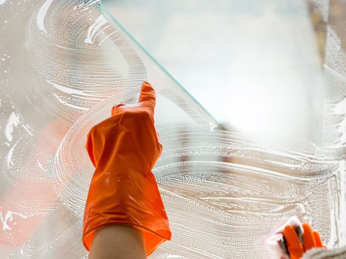 Close Up Hand With Rubber Glove Cleaning Window 1