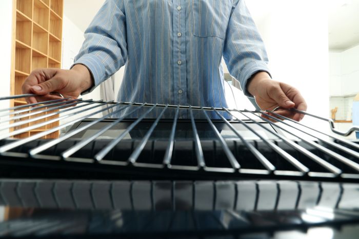 Female Hands With Black Modern Oven
