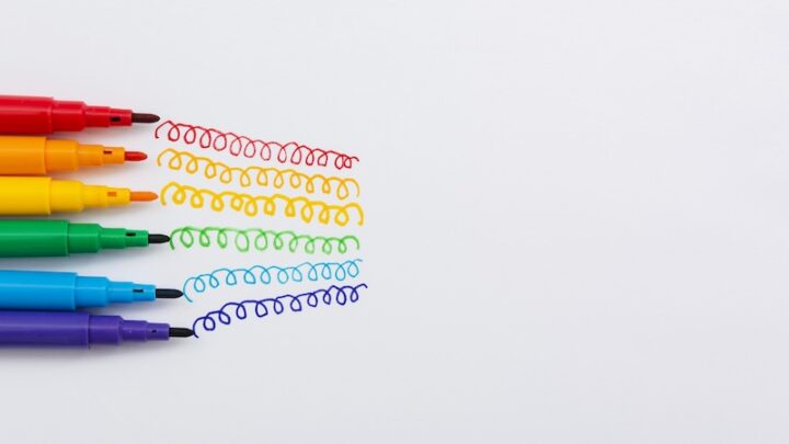 A collection of colorful pens arranged on a white surface, showcasing various hues and designs.