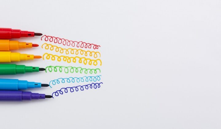 A collection of colorful pens arranged on a white surface, showcasing various hues and designs.