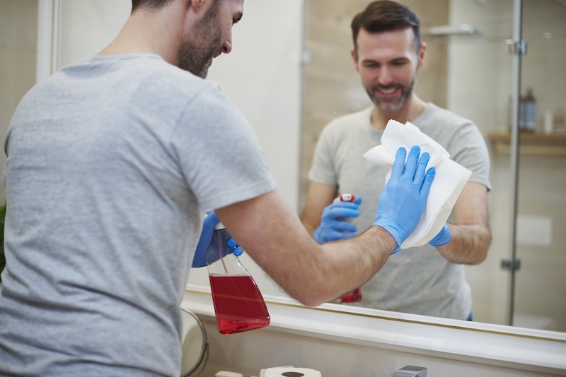 Rear View Man Cleaning Mirror Bathroom