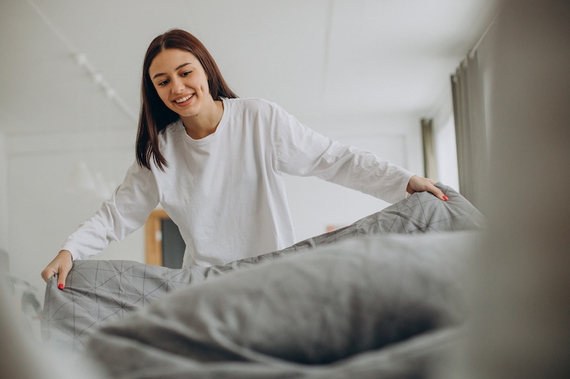 Woman Making Her Bed After Sleep Morning