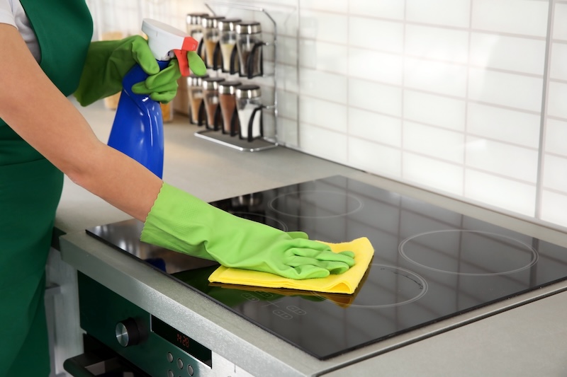 Woman Cleaning Stove Kitchen
