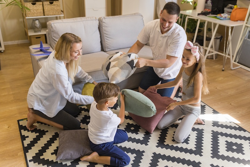 High View Family Playing Living Room With Pillows