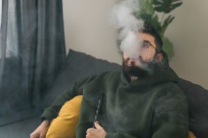 bearded man-smoking hookah while relaxing sofa home chill time resting