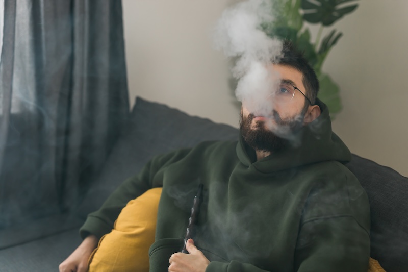 Bearded Millennial Gen Z Man Smoking Hookah While Relaxing Sofa Home Chill Time Resting Concept