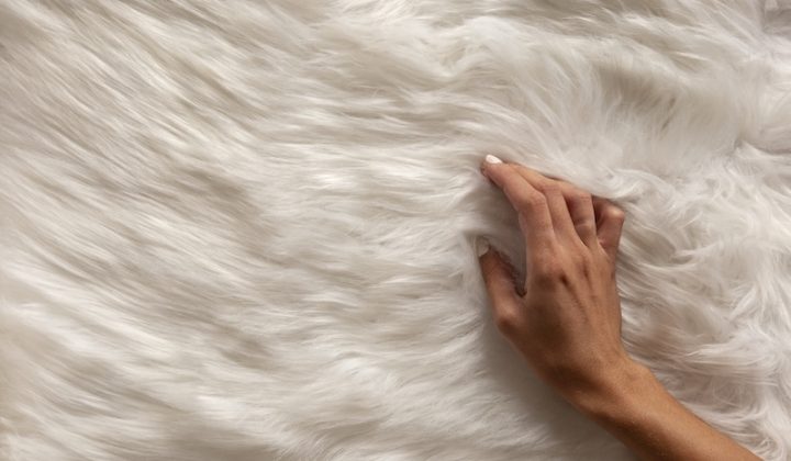 view hand going through textured fur fabric
