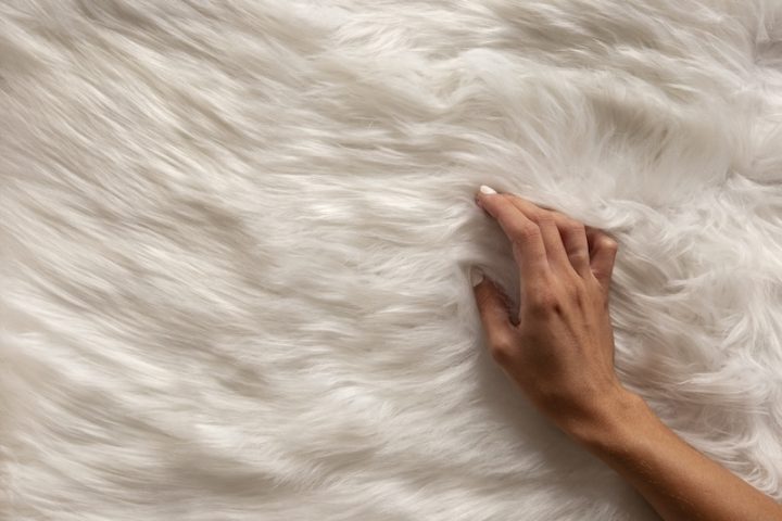 view hand going through textured fur fabric