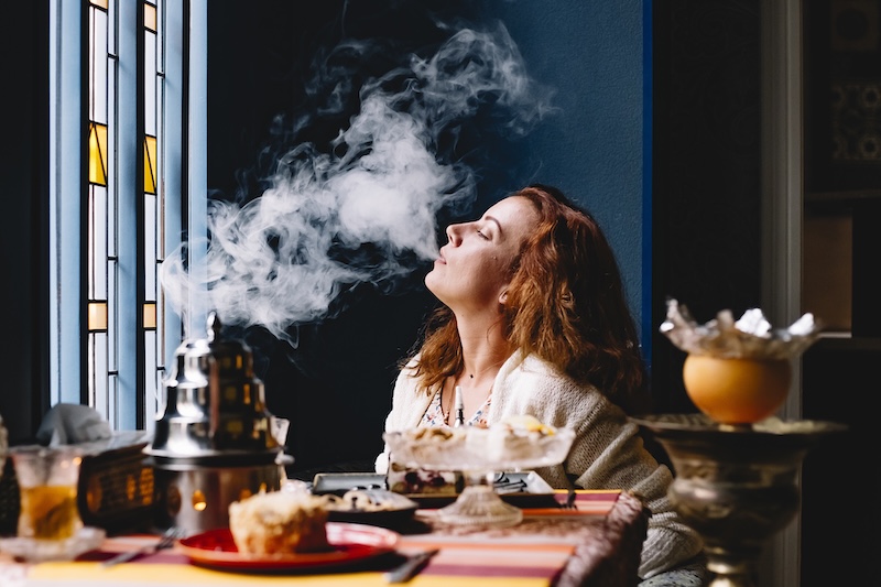 Woman Blowing Smoke From Hookah Restaurant