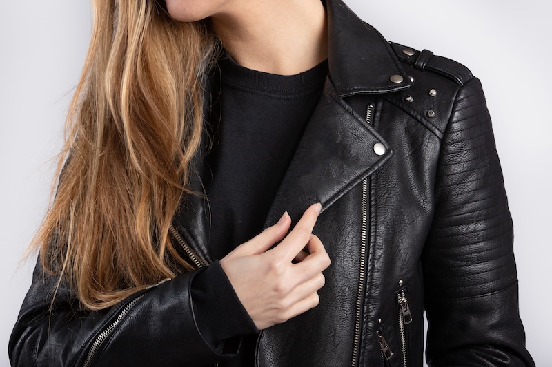 Young Female Wearing Jacket Standing Against White Wall
