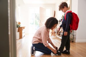 single mother home getting son wearing uniform ready first day school