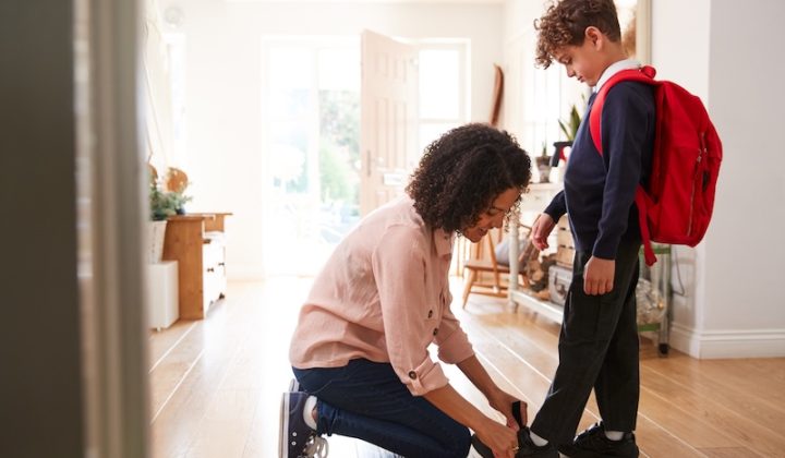 single mother home getting son wearing uniform ready first day school