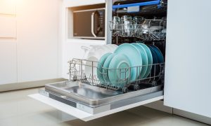 white kitchen opened dishwasher with clean dishes