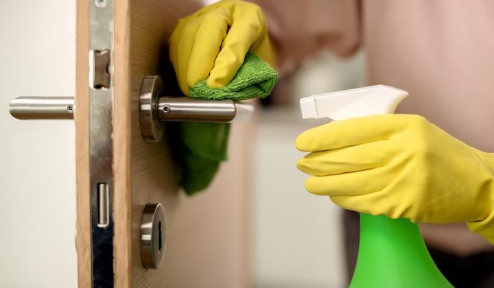 closeup woman disinfecting door handle home