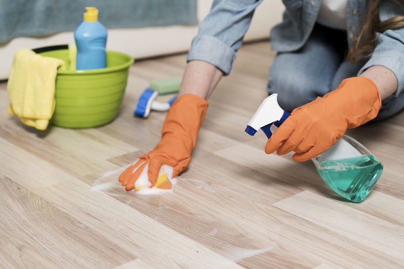 Woman With Rubber Gloves Cleaning Floors